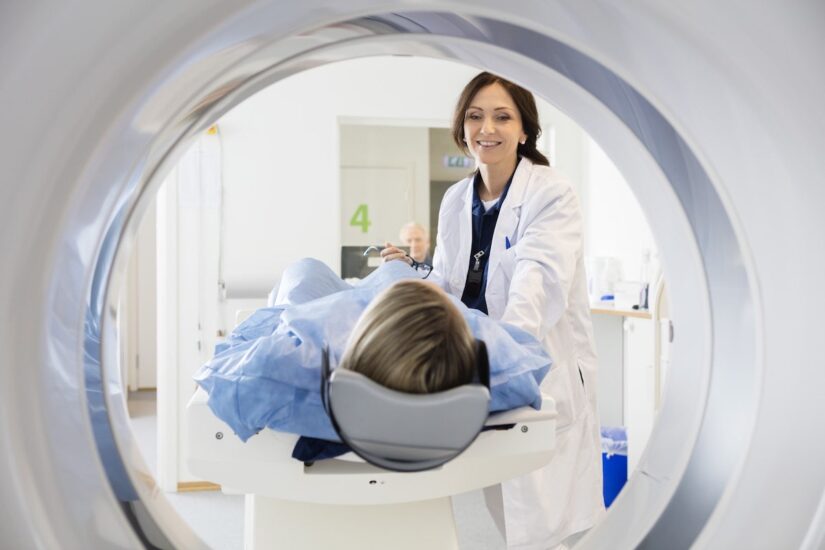 Photo of a doctor pushing patient into a MRI machine