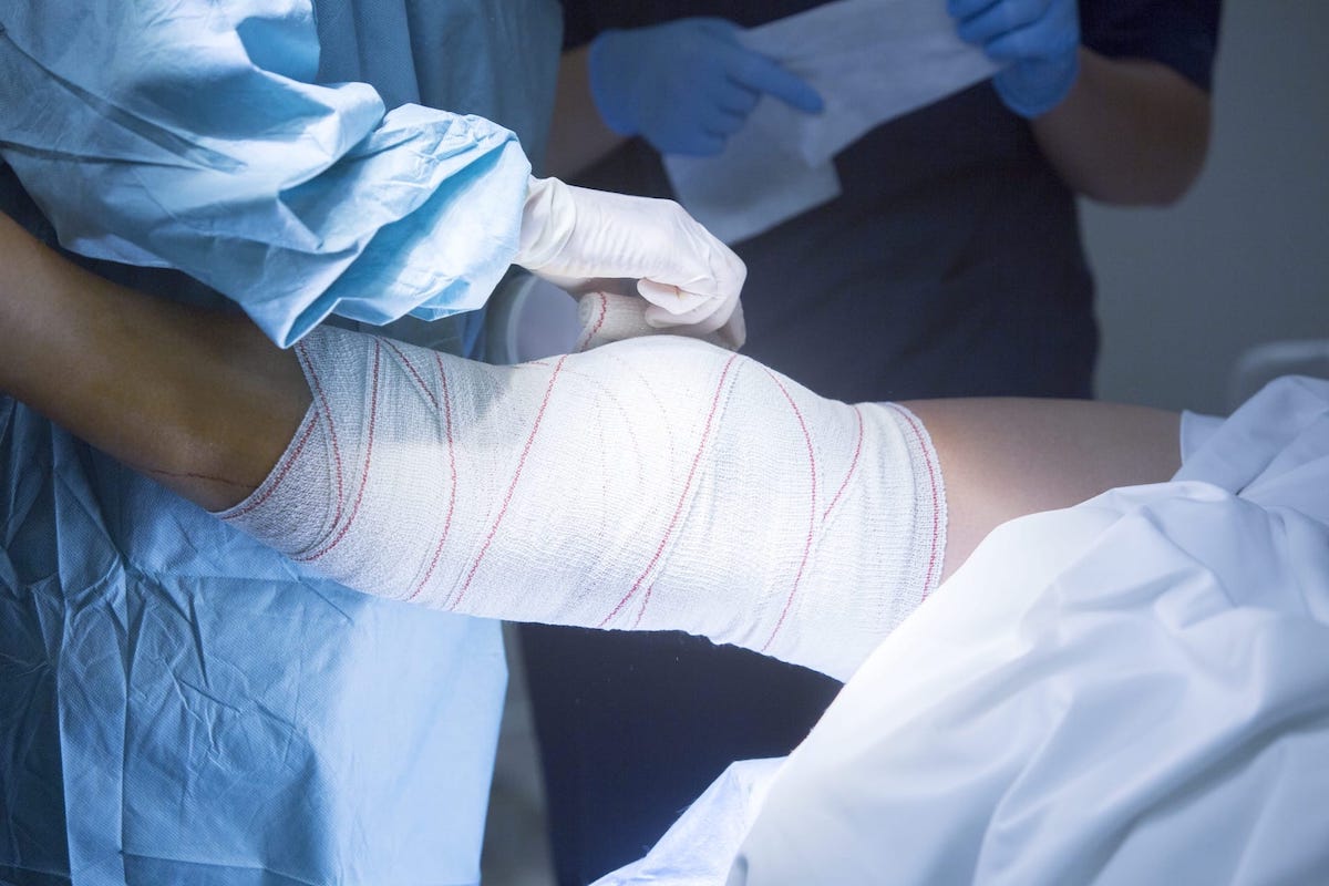 Photo of a doctor bandaging a patient's leg