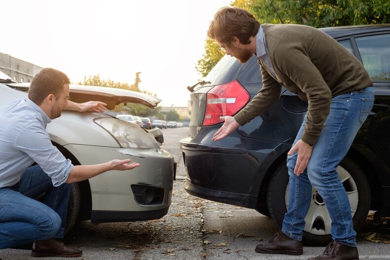 Two Men Arguing Over Their Damaged Cars