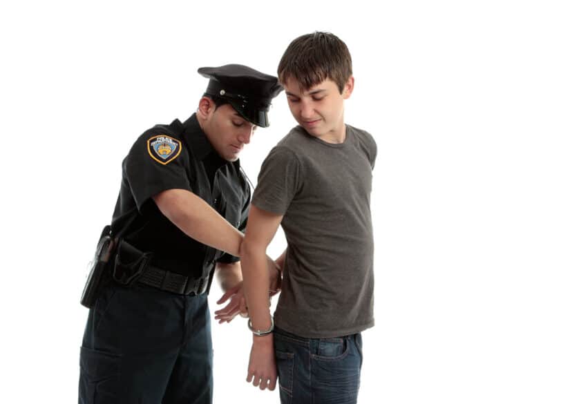 Photo of A Police Officer Arrests a Boy