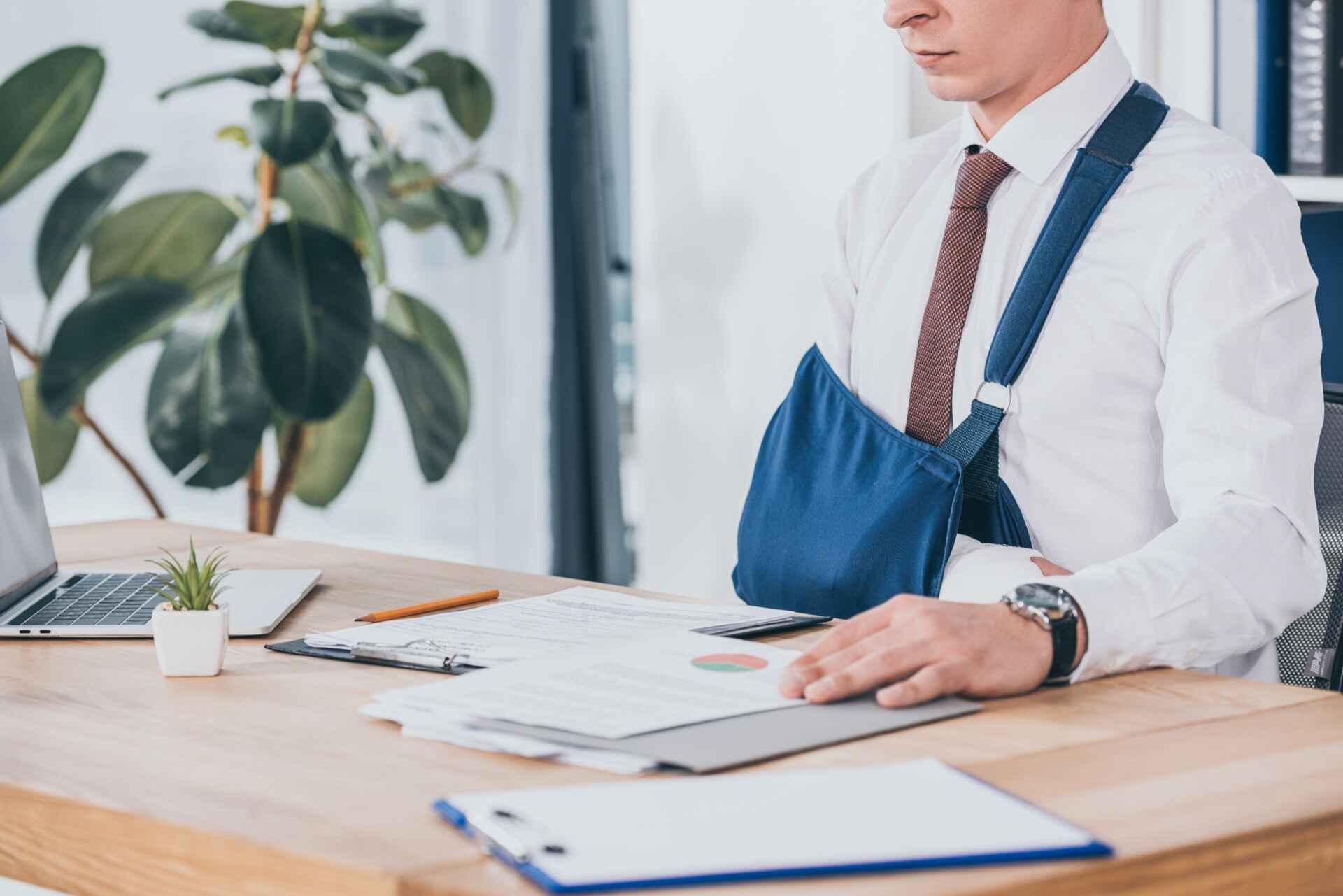 Man with arm injury at desk